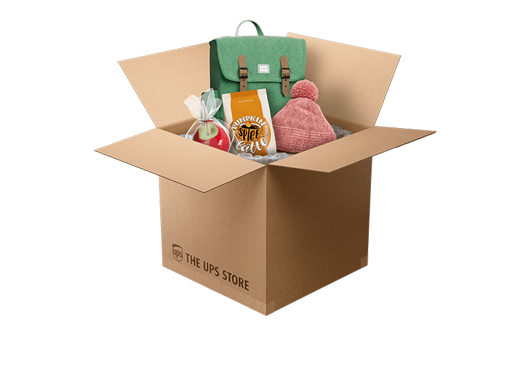open box with a candied apple, pumpkin spice latte mix, a woolen hat and backpack
