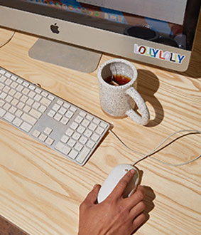Lolly Lolly owner working on a computer with ceramic mug on the desk