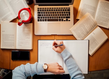 person with books at there computer