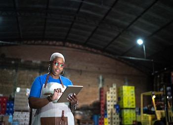 person in a warehouse with digital tablet 