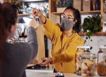 woman at the counter giving a bag to her customer