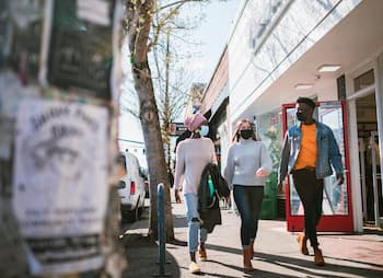 friends walking past open store