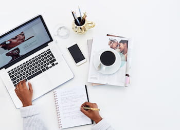 desk with laptop, phone, coffee, and documents