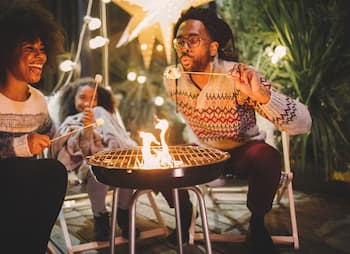 business owner and family roast marshmallows at night