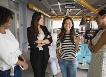 women employees welcome new employee to team