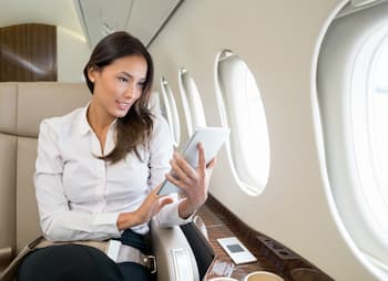 businesswoman on plane with ipad