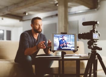 man small biz owner records video for website