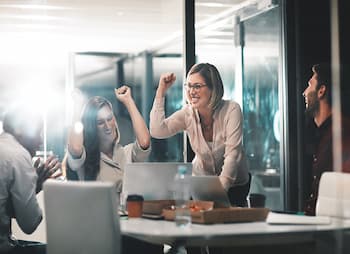 Two woman cheer in an office 