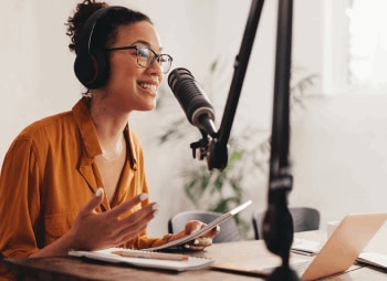 woman speaking into a microphone for podcast