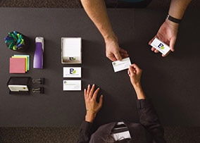 The UPS Store associate hands professional printed business cards to customer