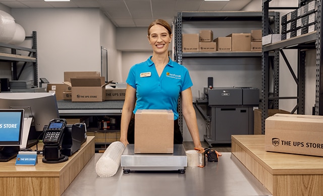 The UPS Store associate with a box
