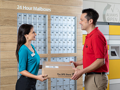 Female associate handing package to male customer