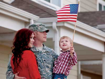 Familia militar con un niño pequeño sostiene la bandera
