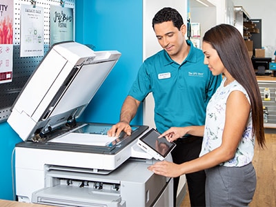 Associate at The UPS Store assisting a customer making copies