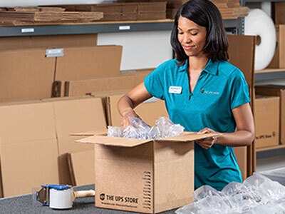 Customer handing gifts to associate for shipment