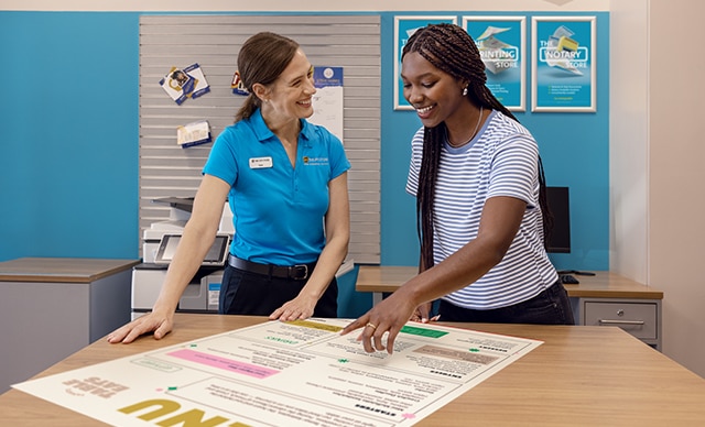 Un asociado de The UPS Store ayuda a un cliente con un póster impreso.