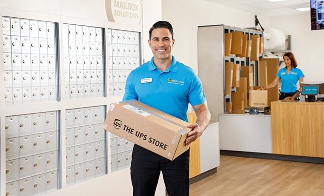 Un empleado de The UPS Store con una caja