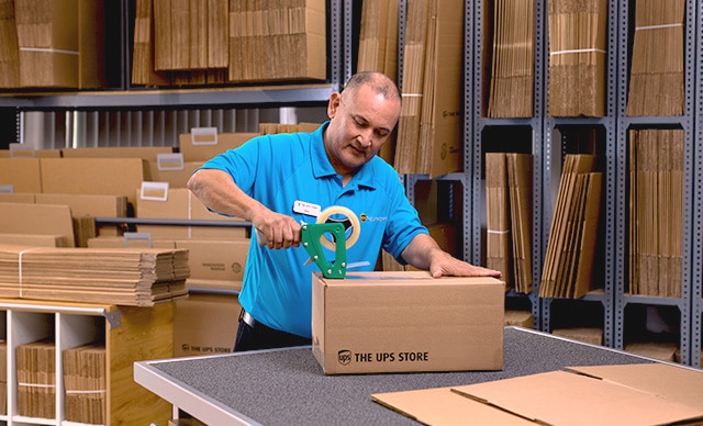The UPS Store associate assisting a customer with shredding documents