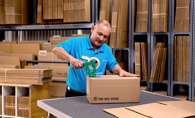 The UPS Store associate assisting a customer with shredding