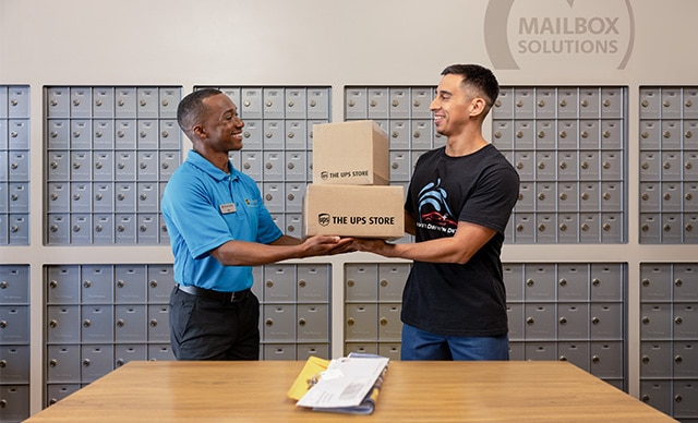 The UPS Store associate assisting a customer with their mail