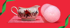 Fragile gravy boat being packed in bubble cushioning