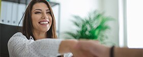 Woman shaking a person's hand during a job interview