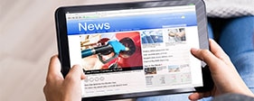 Person using a tablet to view online newsletter