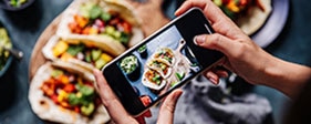 Person taking photo of a tacos plate using a smartphone