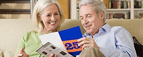 Senior couple examining mail advertising on a couch