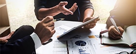 Group of people examining market research papers