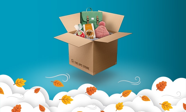 IMAGE OF THE UPS STORE BRANDED BOX WITH FALL ITEMS INSIDE. FALL LEAVES ARE SHOWN OVER CLOUDS AT BOTTOM OF FRAME.