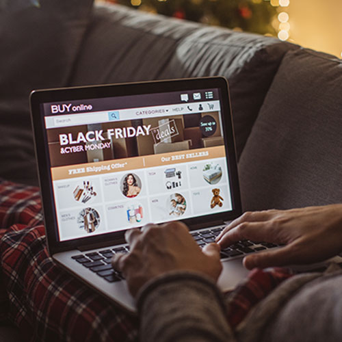 Close-up of a person shopping on their laptop for Black Friday