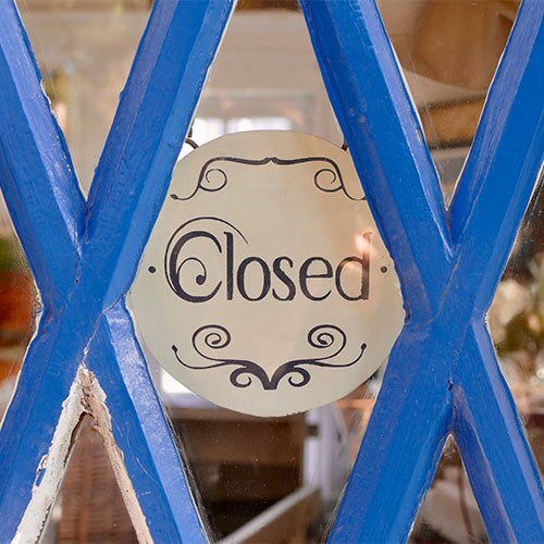 Closed sign hanging in a business window