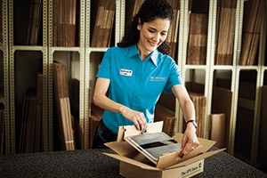 Electronic tablet being packed by store associate