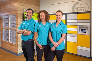 Associates at The UPS Store in front of 24 hour lockers