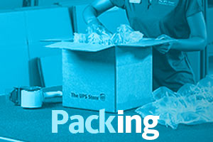 Red-tinted image of associate packing a shipping box